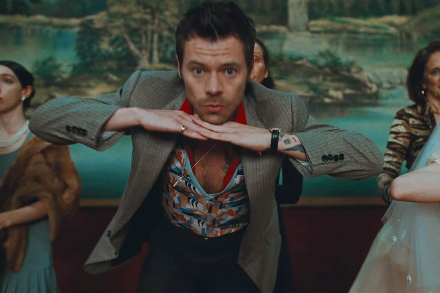 Harry Styles davanti al fondale lacustre: un gesto individuale dentro la coreografia collettiva.